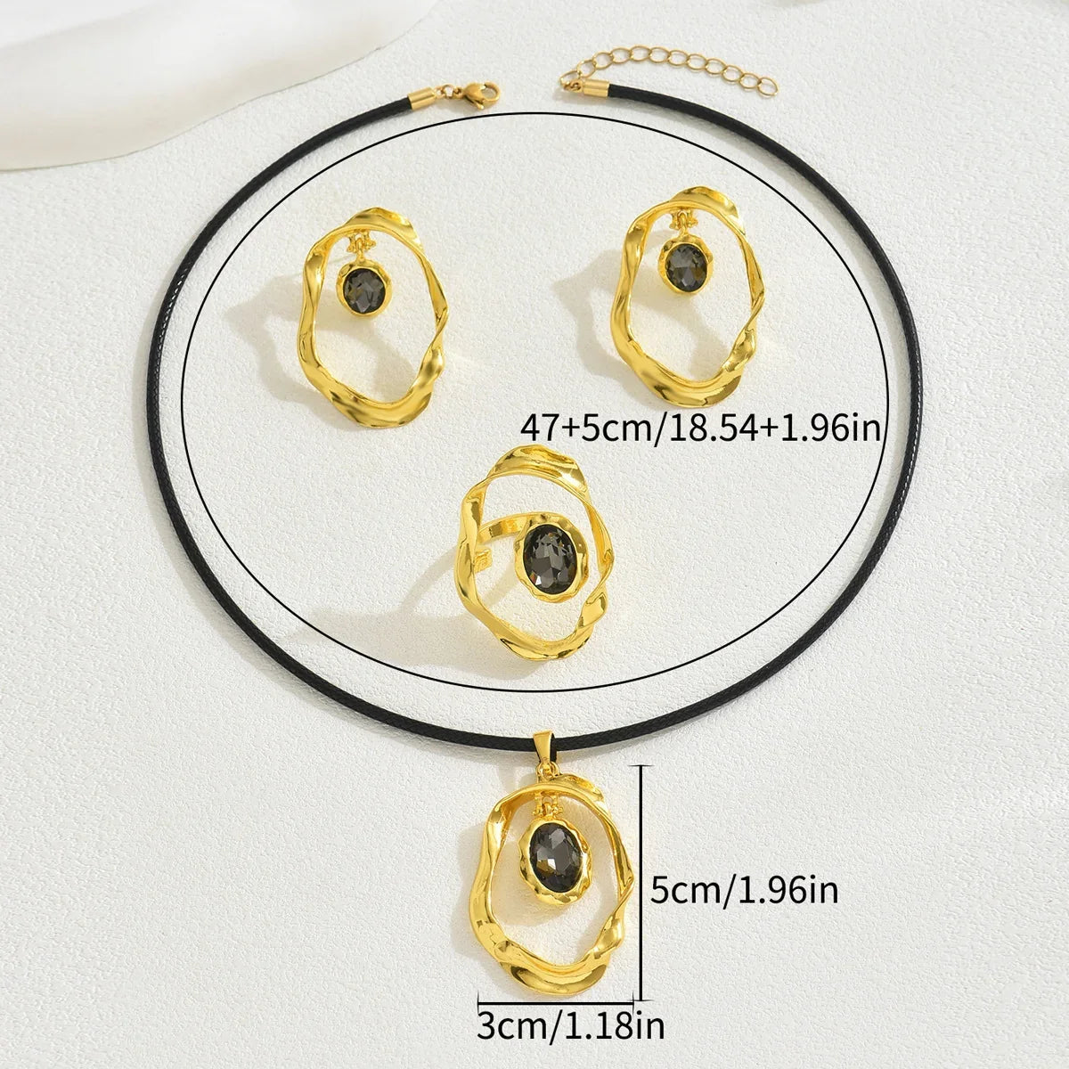 Gold-toned jewelry set featuring an irregular oval necklace, ring, and earrings with dark gemstones.