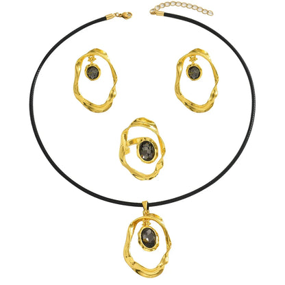 Gold-toned jewelry set featuring a necklace, earrings, and a ring with dark grey gemstones.